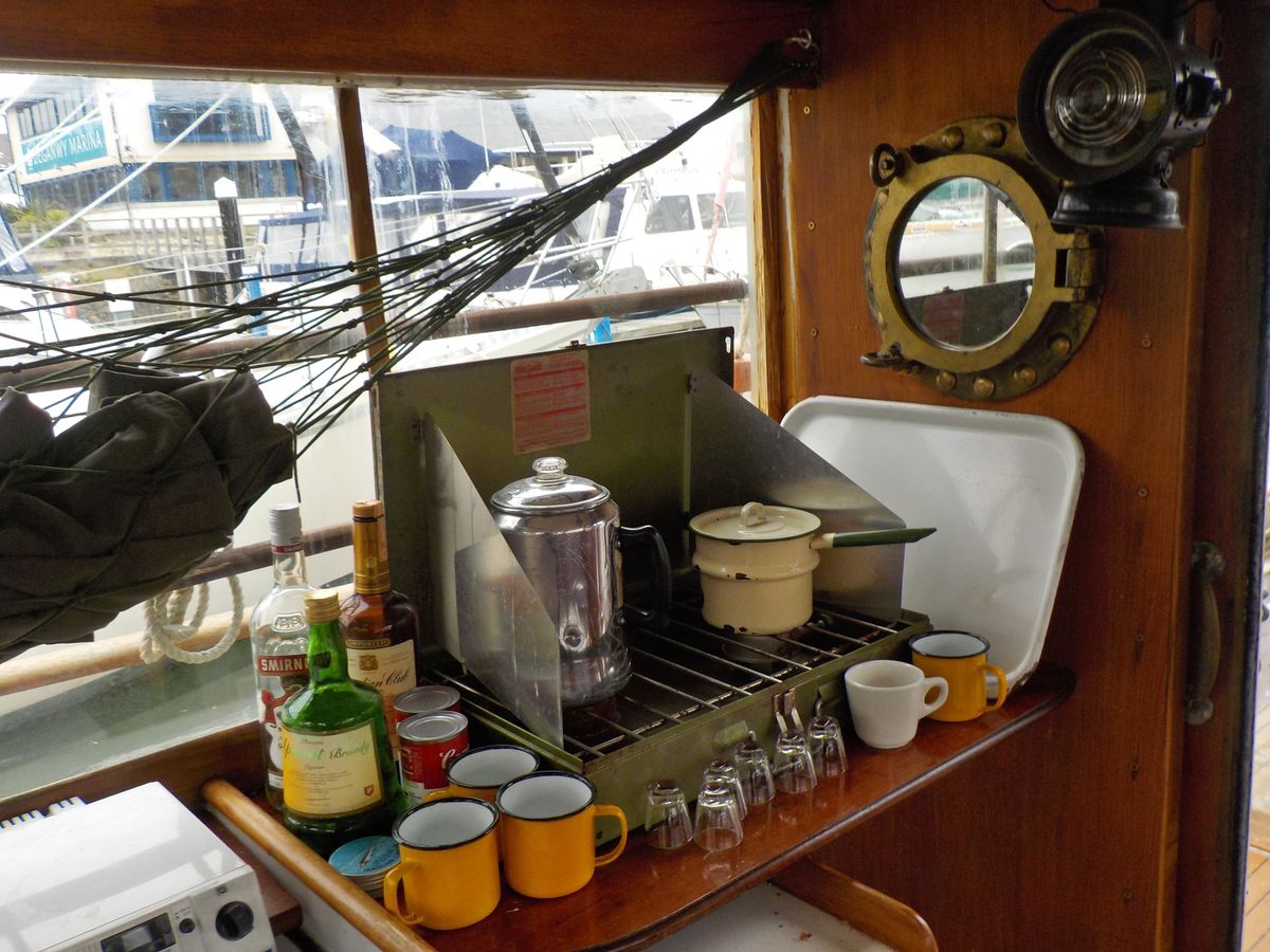 Orca 11's galley with detailed pictures of the stove, drinks and original equipment. Above the kitchen area is Quint's hammock  