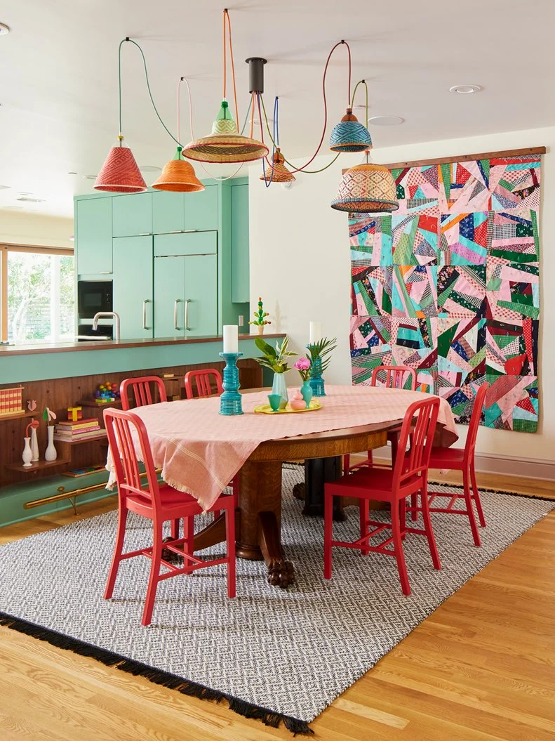 A colorful dining room with a vintage hanging quilt