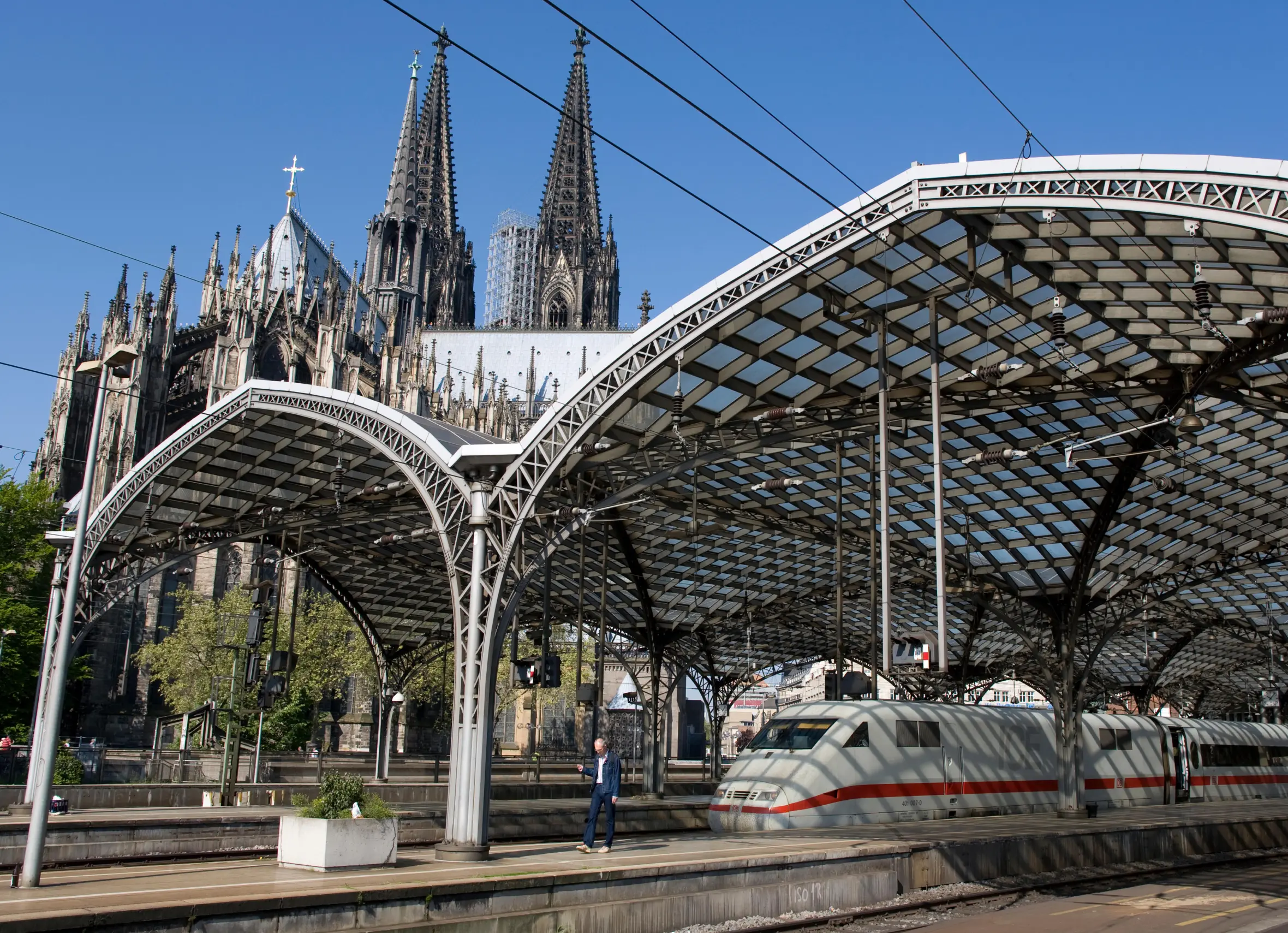 ICE high-speed train at Cologne Central Station, with Cologne Cathedral in the background.