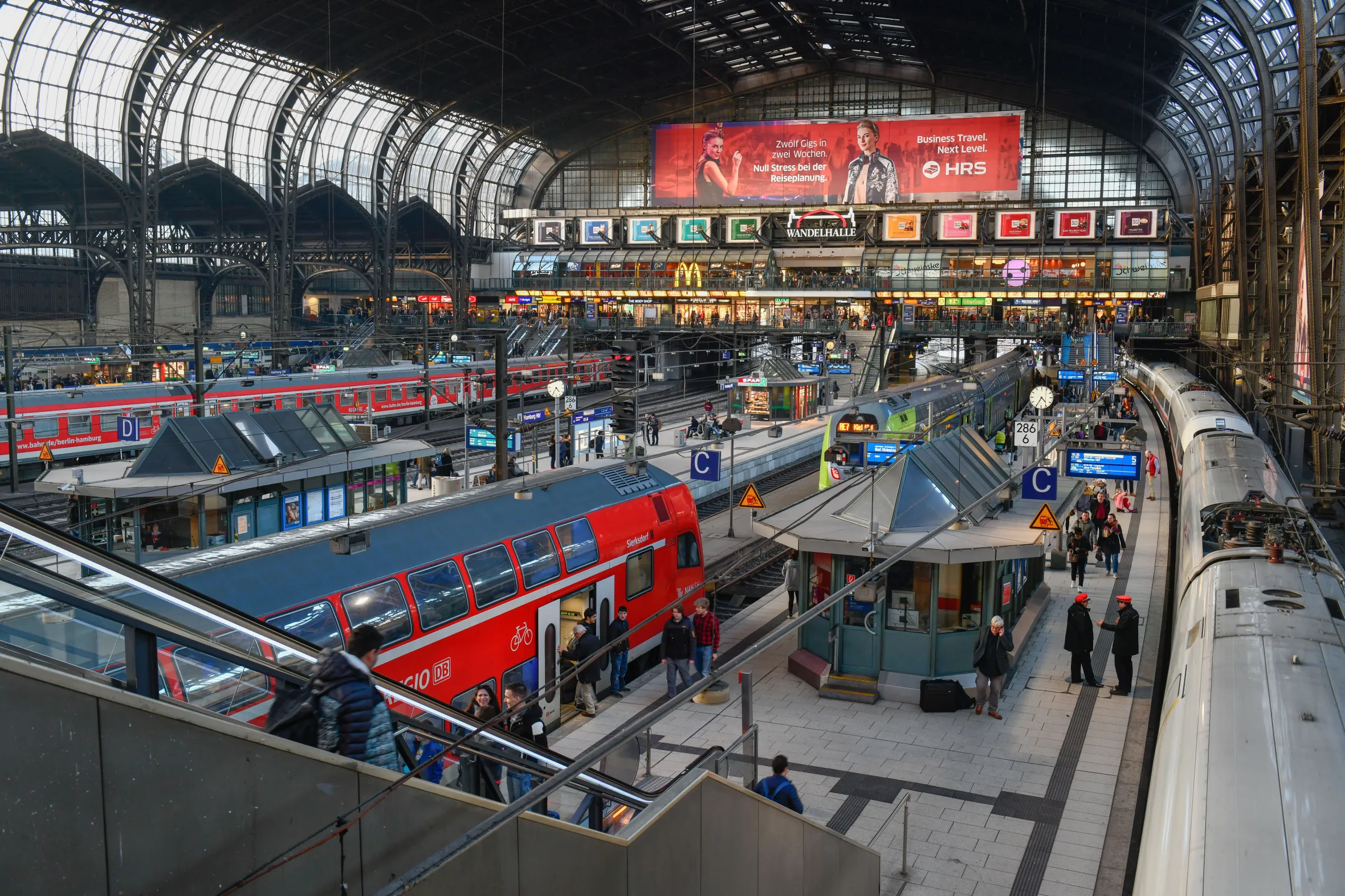 Elevated view of trains and passengers at Hamburg Central Station.