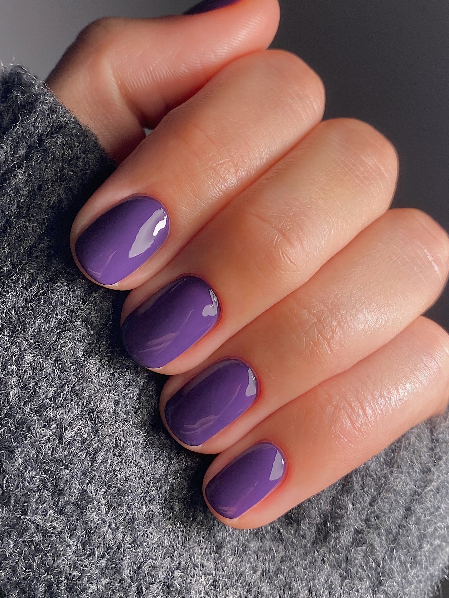 A short, bright purple manicure