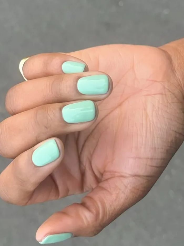A close-up of a mint manicure