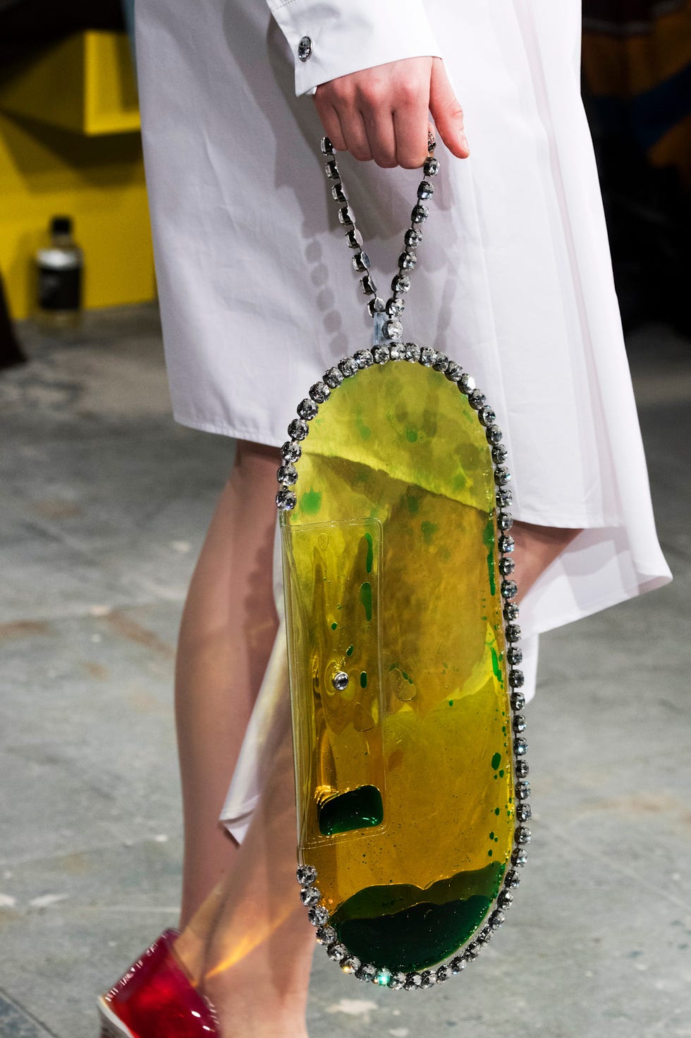 A unique bag with an oval shape and a jewel-like handle.