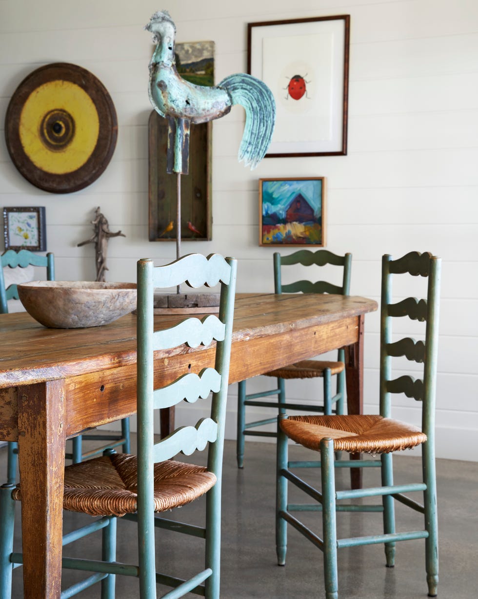 living room with pine farmhouse table with rooster vanes on top and green ladder back chairs