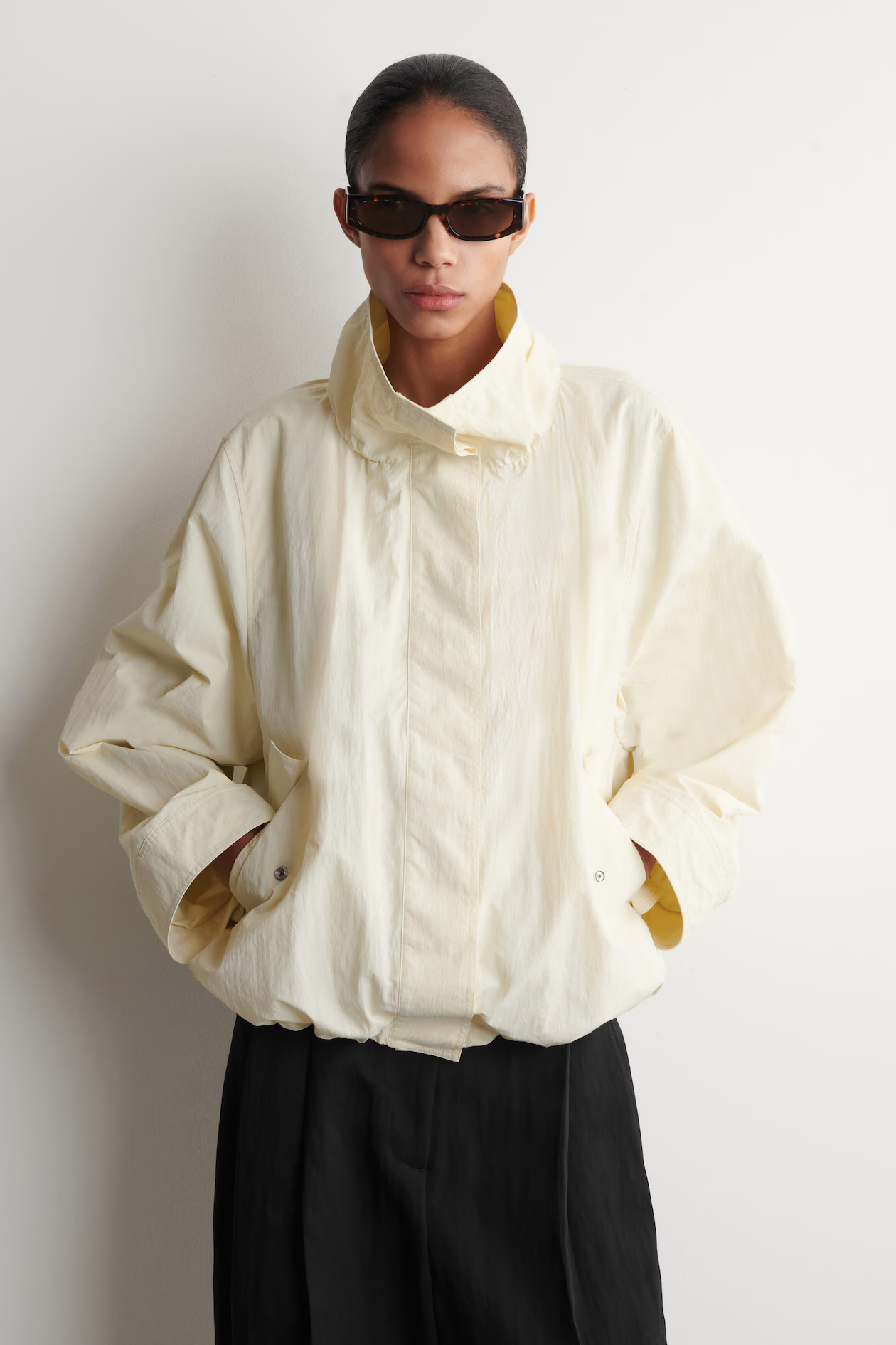 A model wearing a Cos turtleneck jacket.