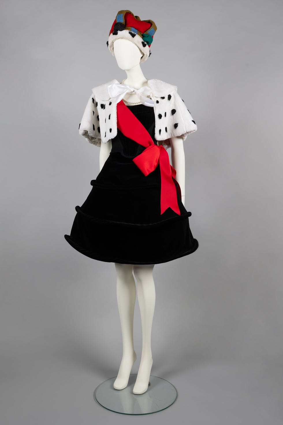 a mannequin outfit with a black dress with a red lining and a fur cape