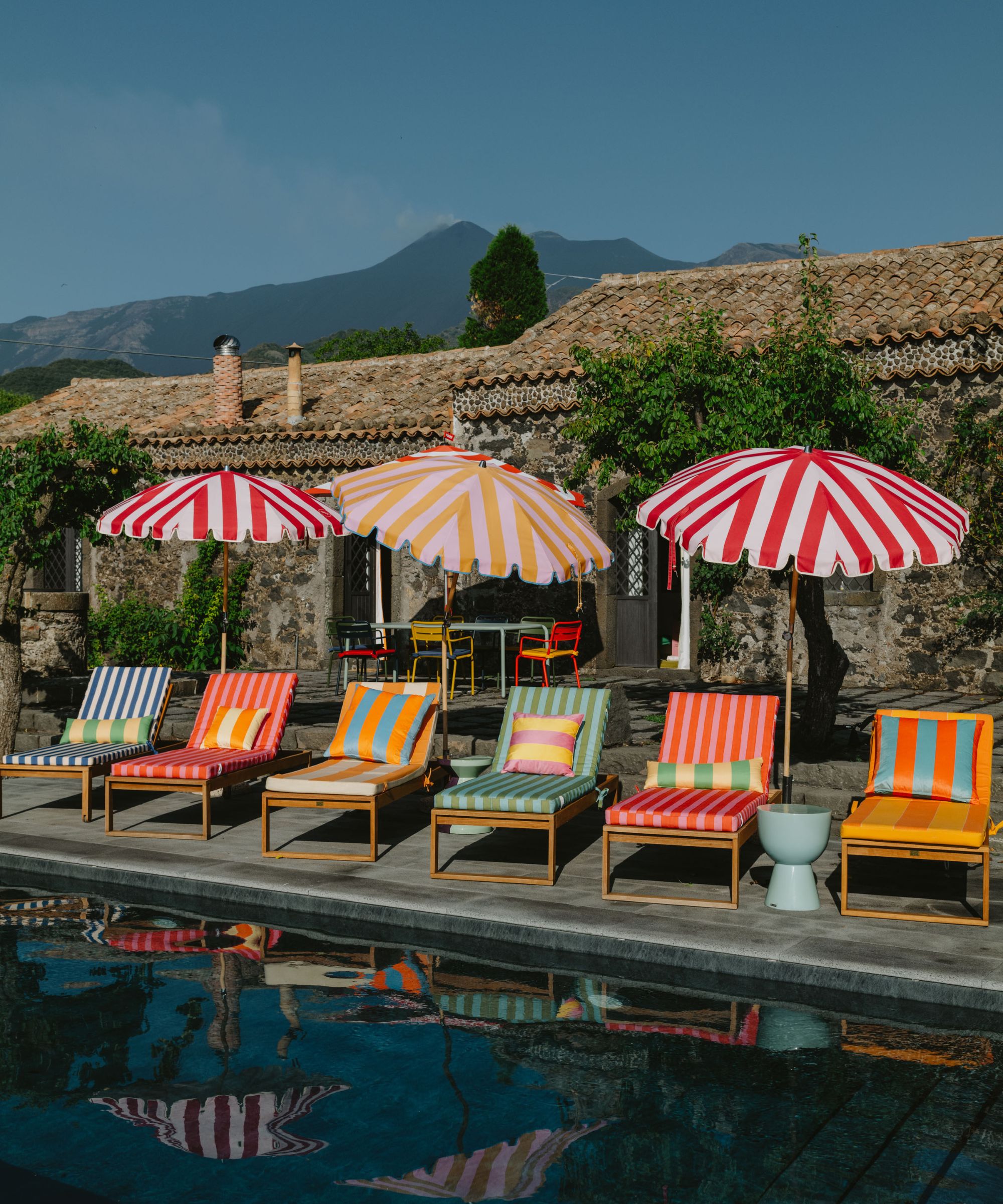 poolside lounger in many colors with colorful umbrellas